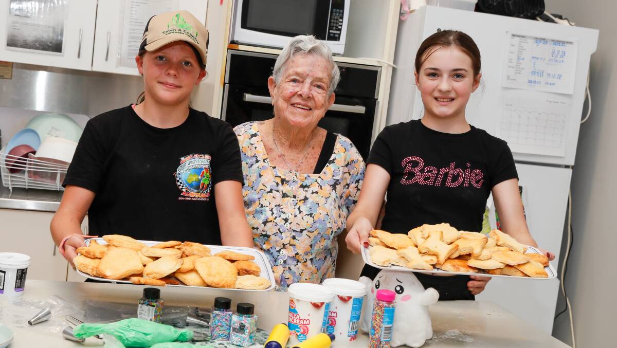 Marie Smith from the RSL Remembrance Village with Libby Evans, 11, and Brooke Bennett-Thain, 12, and some baked goodies. Picture by Les Smith
