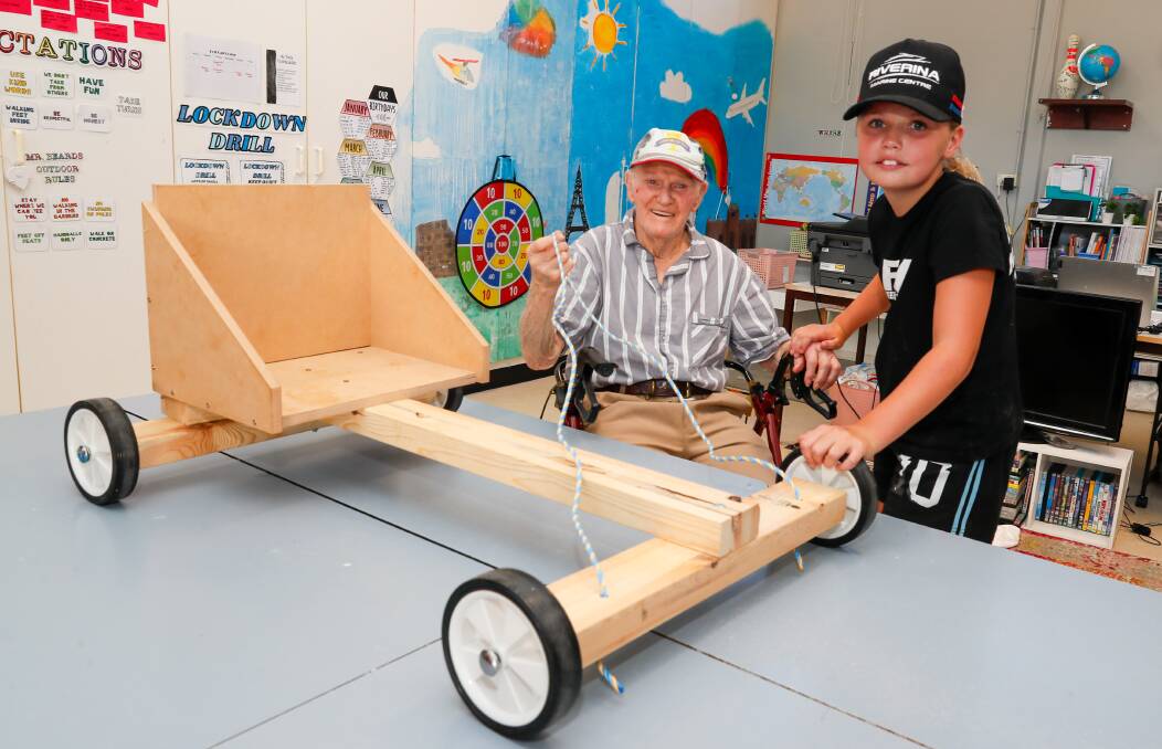 Emlee Aiken, 11, from Henschke Primary School with Mick Sutcliffe from the RSL Remembrance Village and their billycart. Picture by Les Smith