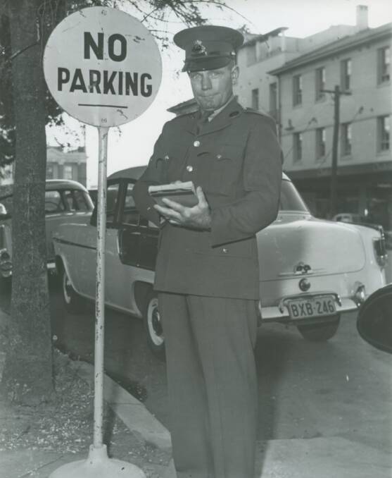 LONG ARM OF THE LAW: A brown bomber parking inspector during the 1960s or late 1950s in Wagga's Sturt Street, outside the Court House. Picture: Peter Gissing