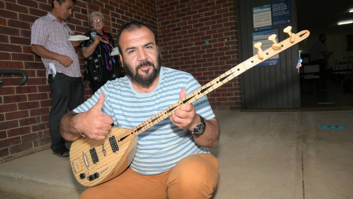 STAR: Yazidi refugee Kheri Shngale plays a traditional tune on the tambour. Picture: Kenji Sato