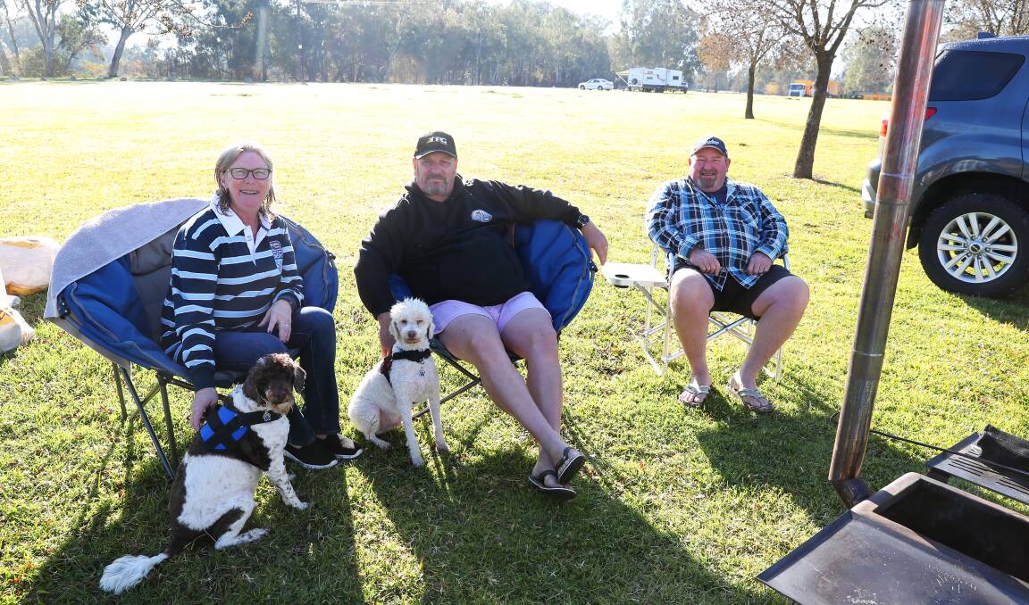 HAPPY CAMPERS: Sandra Bell, Brett Bell, and Peter Garland soak in the sun with Moe and Jack the dog. Picture: Emma Hillier