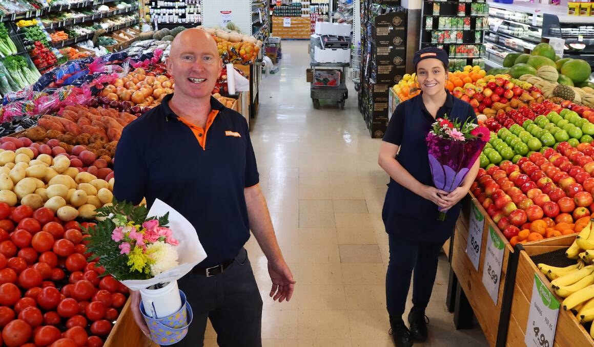HARD WORKERS: Fresh food manager Gavin Mather and deli assistant Molly Addison were given flowers for their hard work. Picture: Emma Hillier