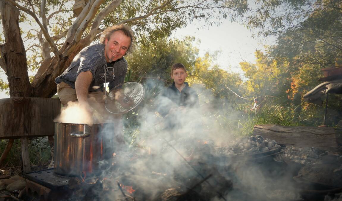 DOUBLE TROUBLE: Eltan Mestan and Lachlan Godber stewing up some native herb stew around the billy. Picture: Kenji Sato