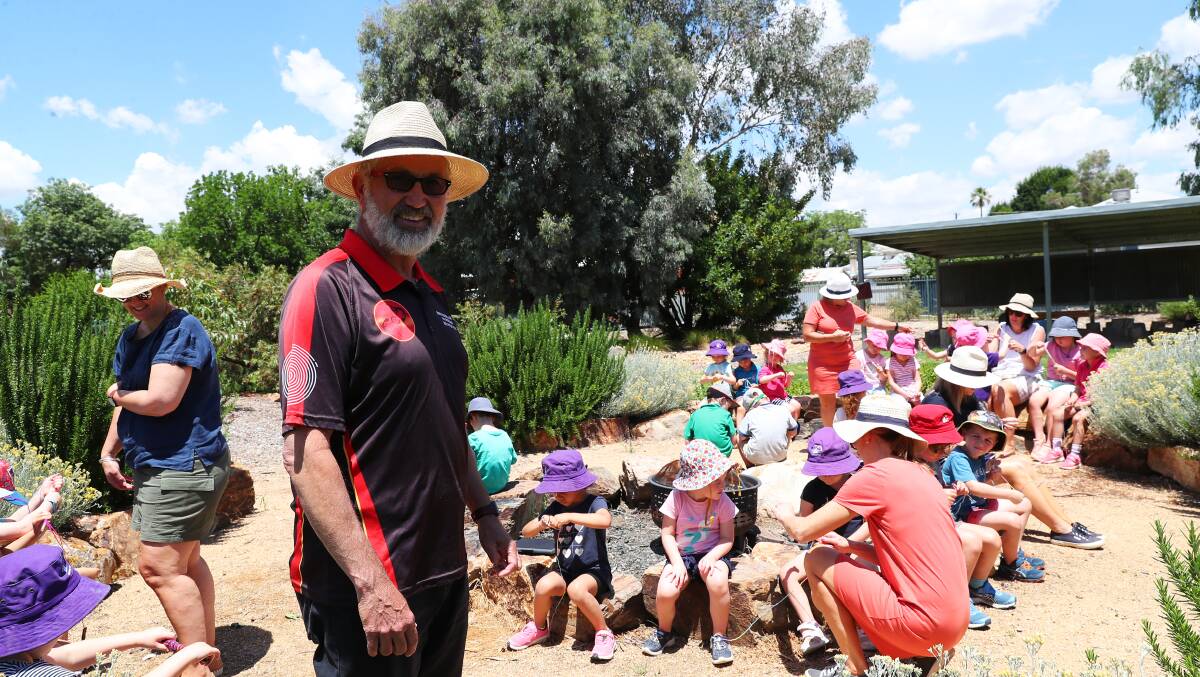 PASSING THE TORCH: Wiradjuri man Mark Saddler passes on cultural knowledge around the firepit at St Mary's Rainbow Preschool. Picture: Emma Hillier