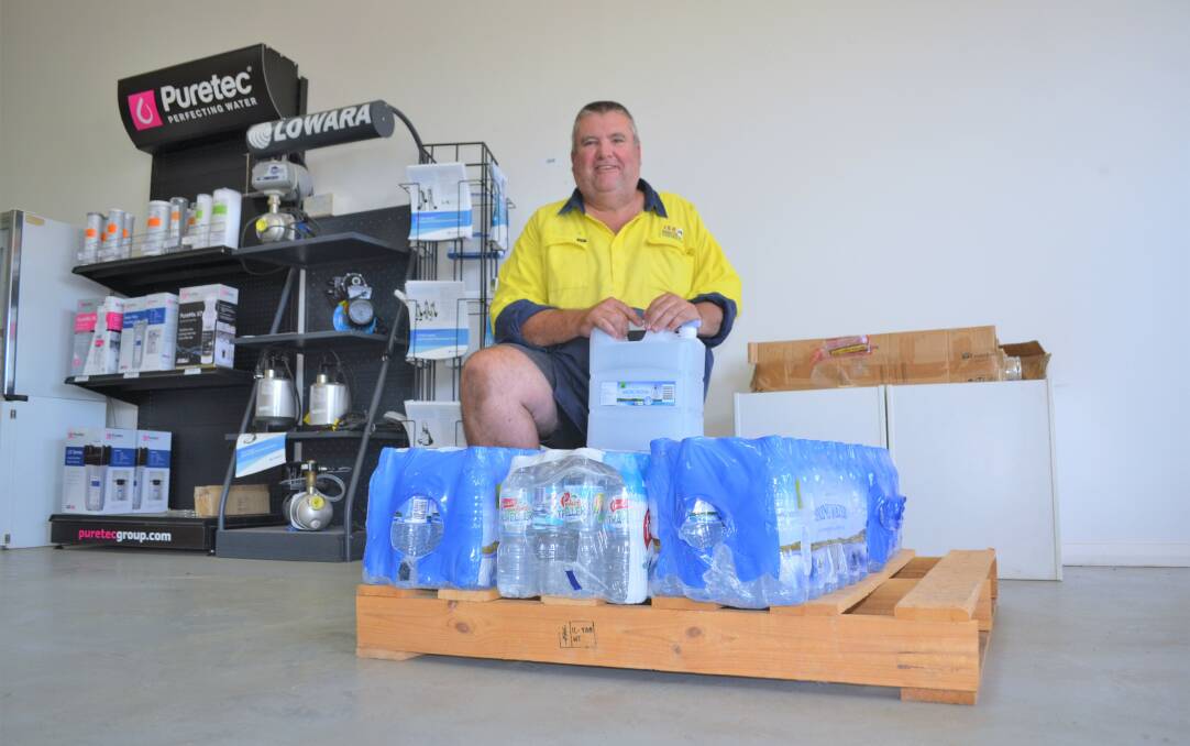 Scott Grinly has been helping to store the pallets of bottled water that have been pouring in from all over town. Picture: Kenji Sato