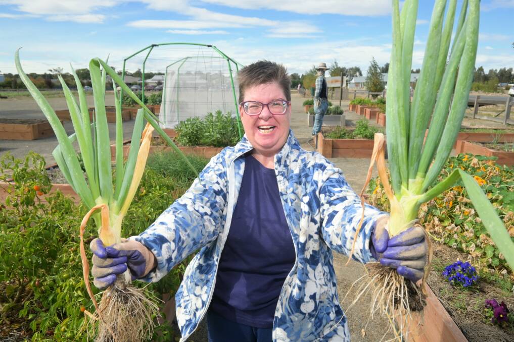 GREEN THUMB: Kellie Hulm with some freshly harvested green onions. Picture: Kenji Sato