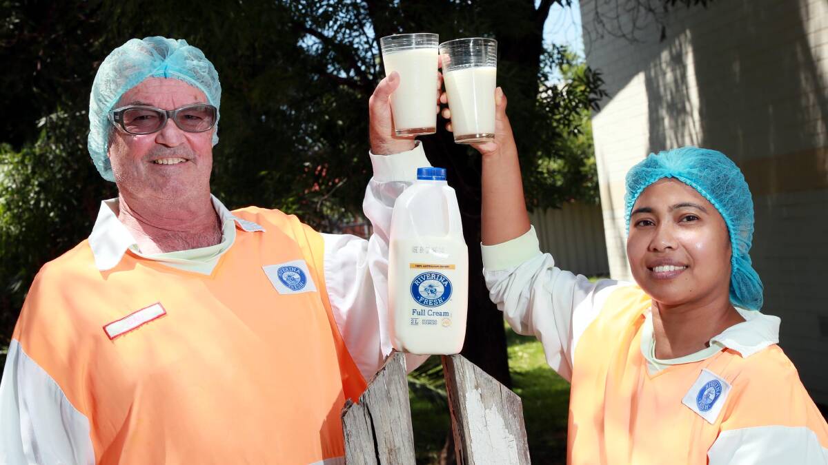 THREE CHEERS: Pasteuriser Dan McCallum and lab technician Sadhana Adhikary celebrate with a glass of Riverina Fresh milk. Picture: Les Smith