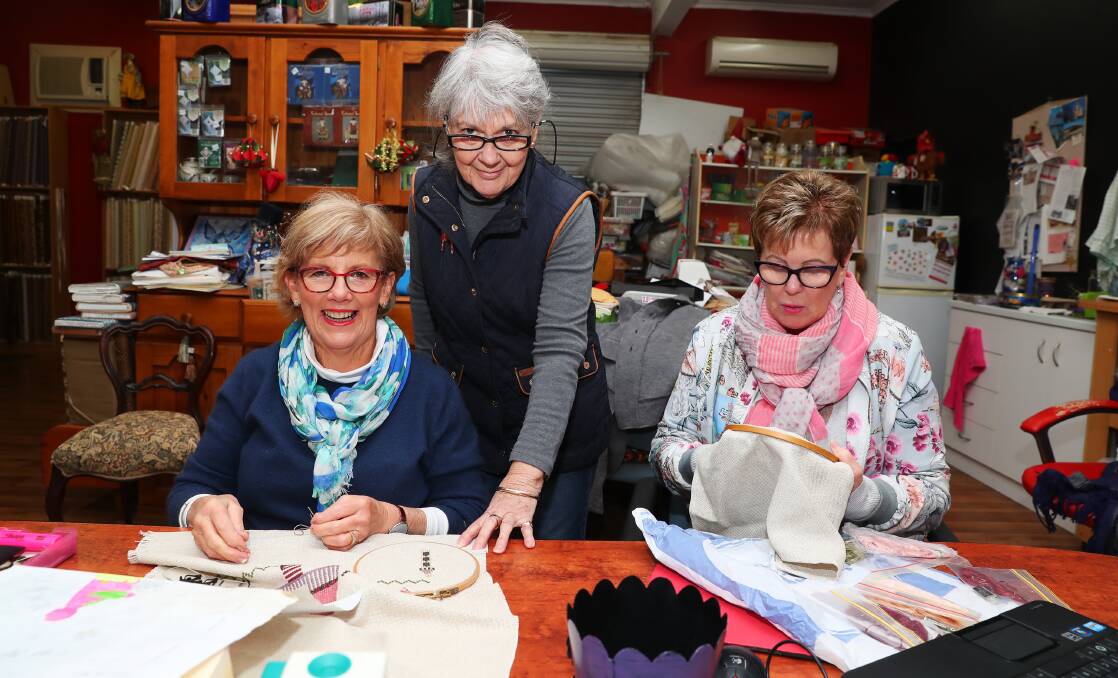 CLOSE-KNIT: Kate Hand, Maria Flinn and Lyn Mooney work on their embroidery. Picture: Emma Hillier