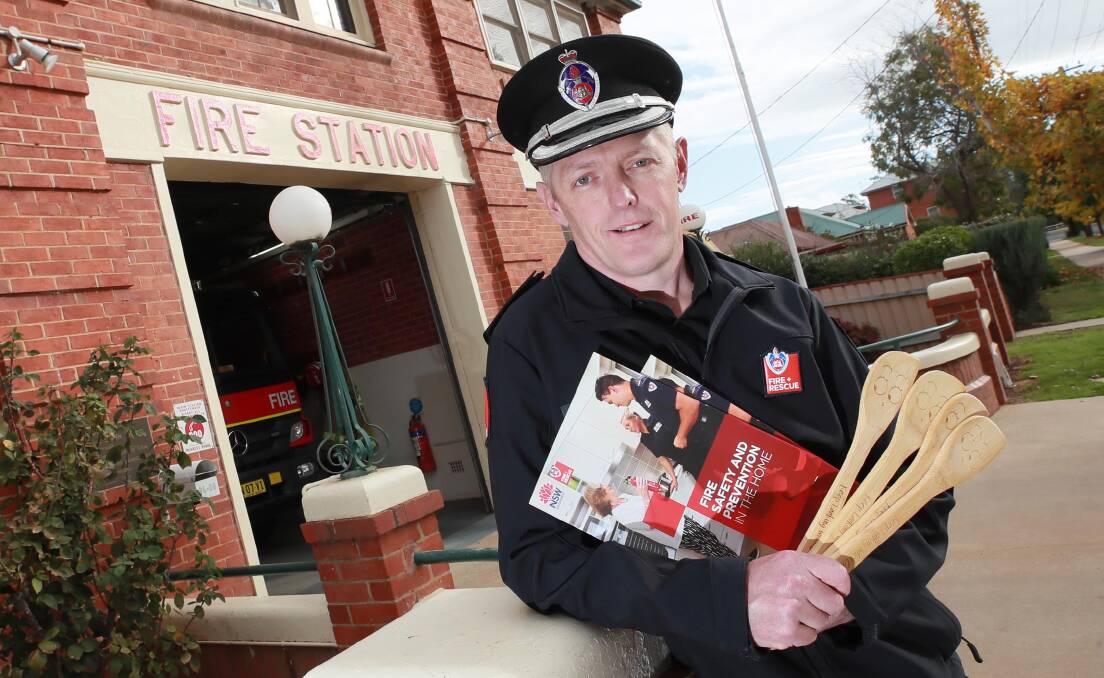 STAY SAFE: Wagga FRNSW Duty Commander Daryl Manson with fire safety brochures and 'keep looking while cooking' spatulas. Picture: Les Smith