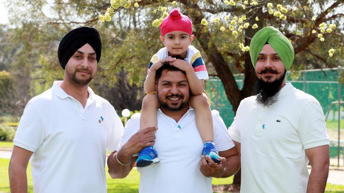 COMMUNITY:Jai Singh, 3, on the shoulders of Ravinder Singh with Gurwinder Singh and Daman Deep Singh before the walk. Picture: Les Smith