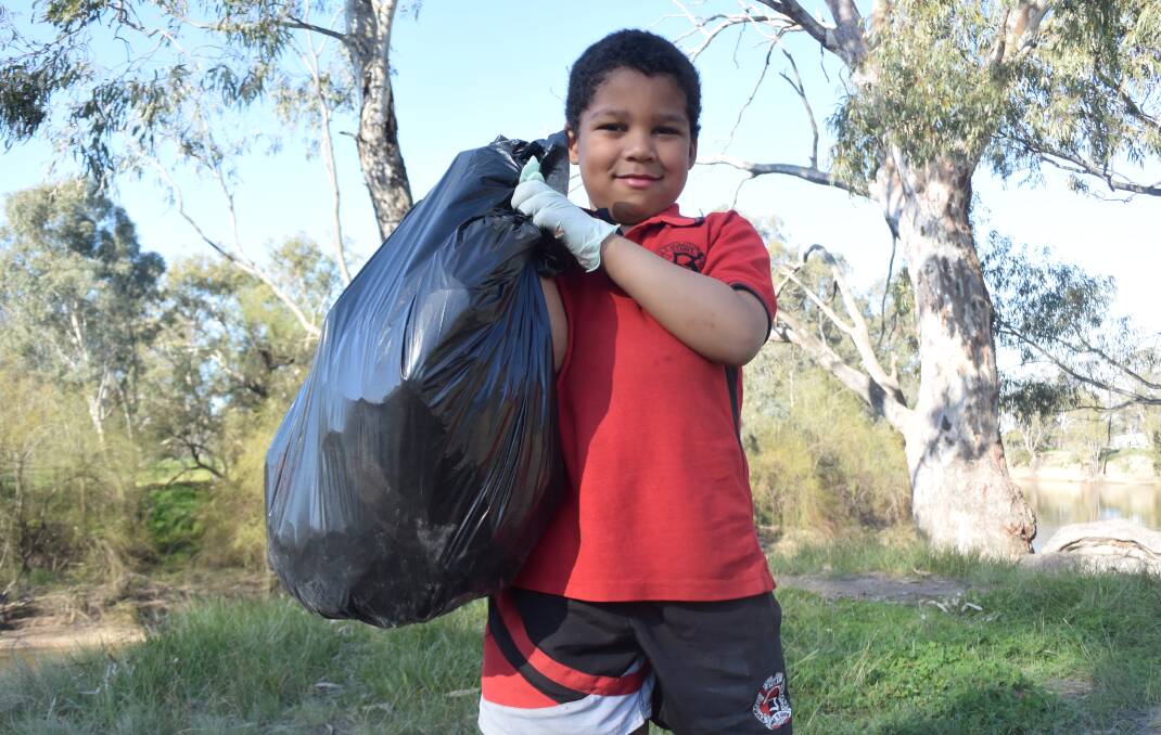 FAMILY EFFORT: Kathryn Dedini's son Agang Alew, 5, helps his mum clean up food wrappers and other non-dangerous rubbish left around Wagga. Picture: Catie McLeod