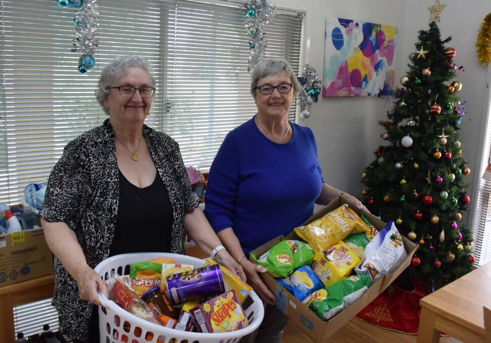 COMMUNITY SPIRIT: Ingenia Gardens social committee president Lida Vanlierop and secretary Gloria Eden with some of the Christmas hamper items before they were handed over to charity. Picture: Catie McLeod