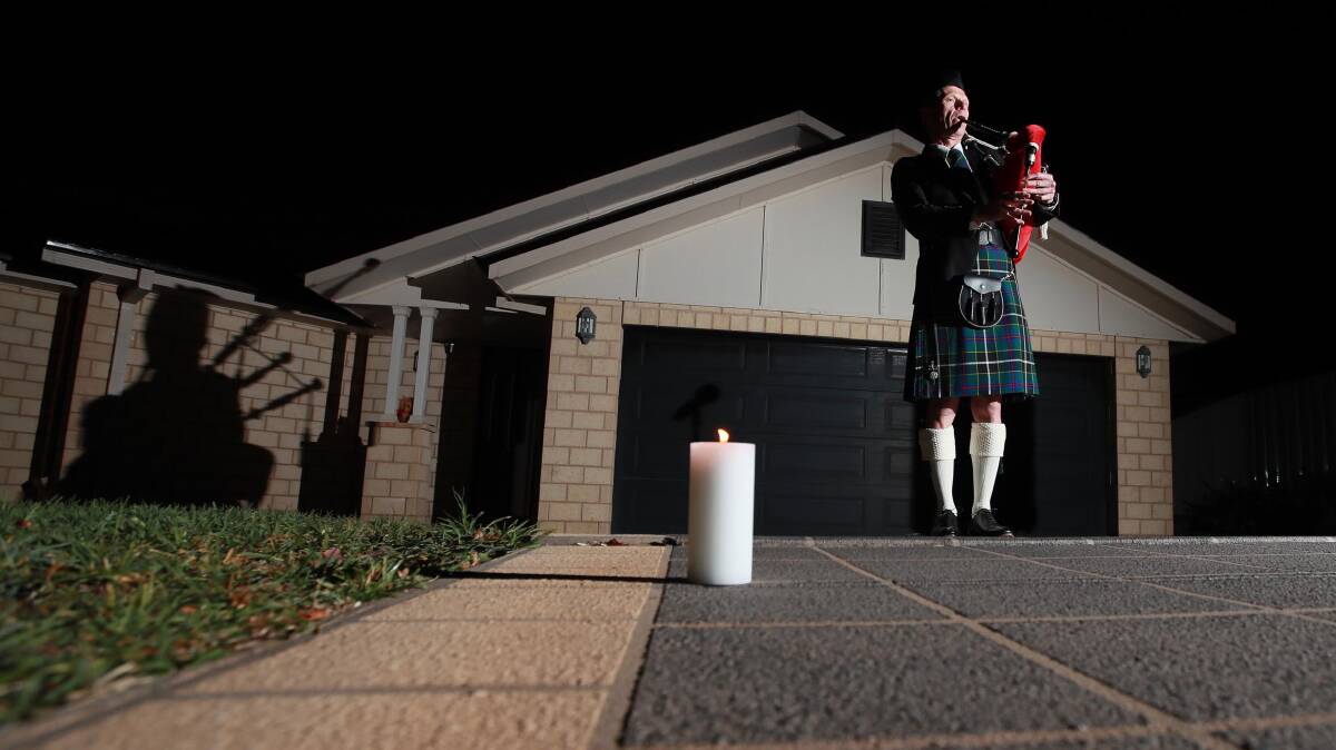 Former Army Band Kapooka conductor Peter Thomas plays the bagpipes as part of a solemn driveway ceremony. Picture: Les Smith