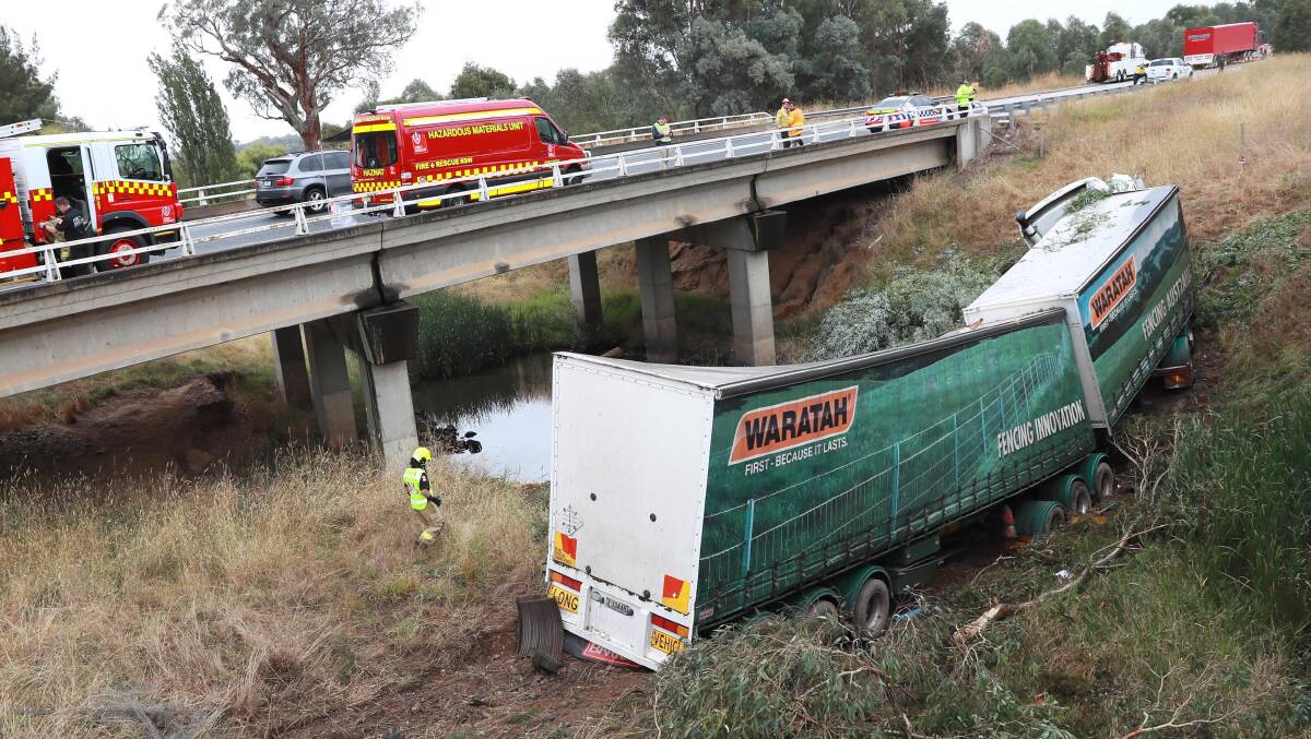 CLEAN UP: Emergency services personnel attend the scene of the crash before the truck is removed. Picture: Les Smith