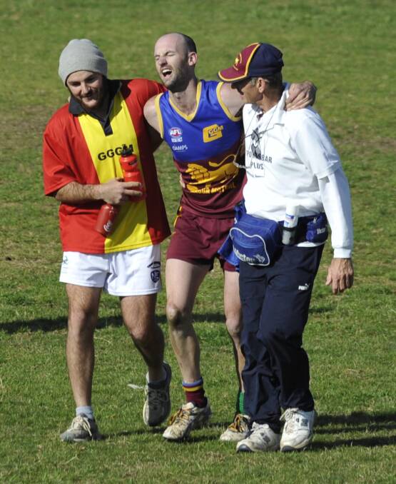 RULES TIGHTENED: Ganmain-Grong Grong-Matong trainer Zane Fraser (right) helps an injured player off during the 2014 season. Picture: Les Smith