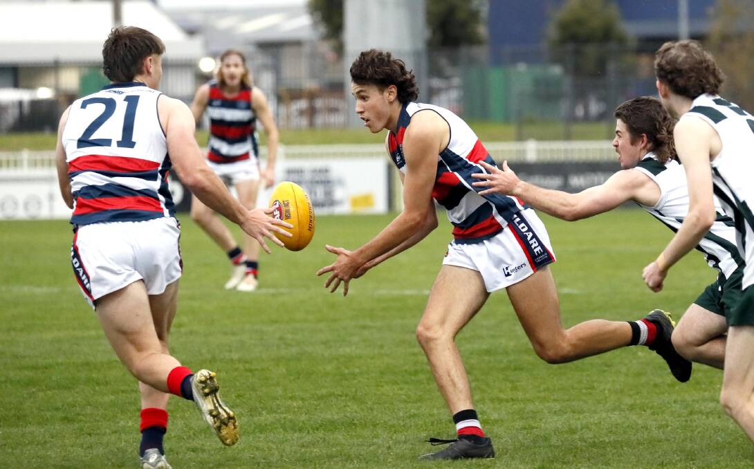 DOMINATION: Kildare Catholic College's Tom Nejman handballs to Kye Wright during Wednesday's win over The Riverina Anglican College. Picture: Les Smith

