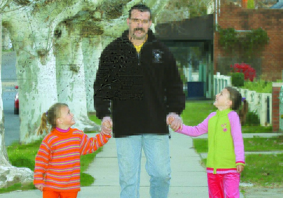GOOD TIMES: Sarah, 5, and Emily, 7, with Mark in 2003. Picture: Michelle Smith.