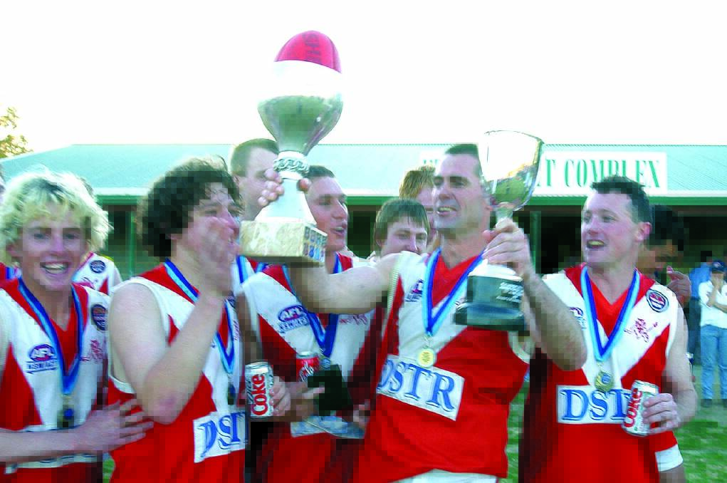 Demons coach Shane Lenon (holding trophies) enjoys the spoils of success after the 2002 grand final. 
