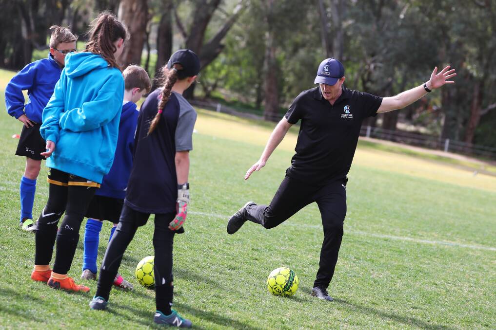 IMPROVING SKILLS: Christian Layland gives Wagga soccer juniors some pointers. Picture: Emma Hillier. 