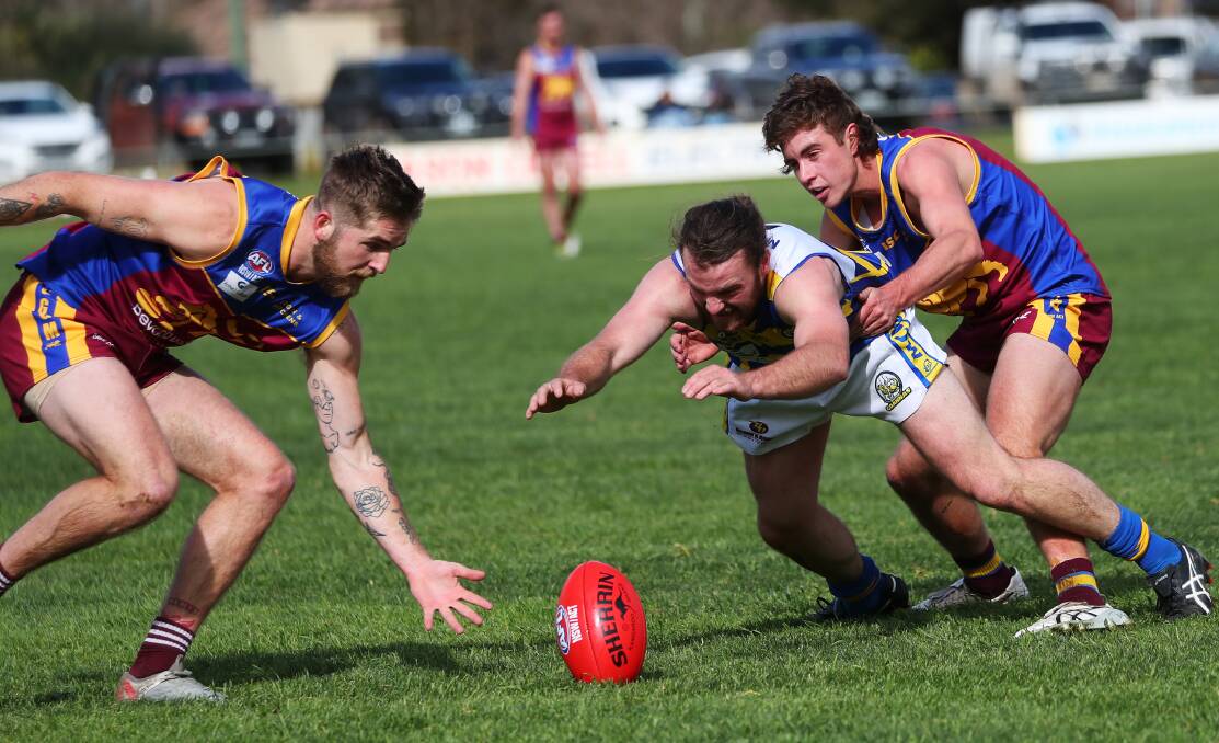 HARD AT IT: GGGM's Sam Martyn (left) and Matt Hamblin battle with MCUE's Padric Griffin during the Lions' win on Saturday. Picture: Emma Hillier