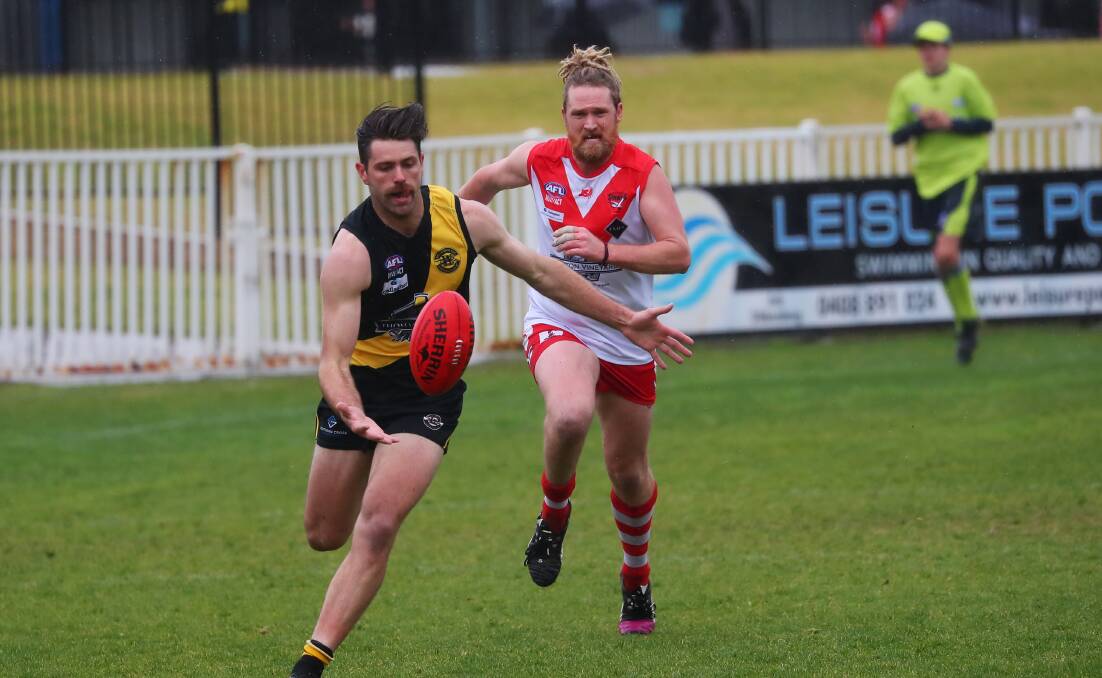 TOUGH SLOG: Wagga Tiger Jock Cornell and Griffith's Ashley Verhagen battle it out in torrid conditions at Robertson Oval. Picture: Emma Hillier