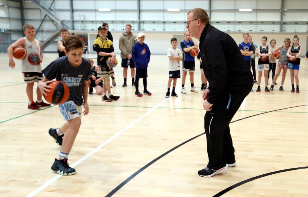 COACHING CLINIC: Leeton's Alex Minato, 13, receives some tips from NBL championship-winning coach Rob Beveridge at Equex Centre yesterday. Picture: Les Smith