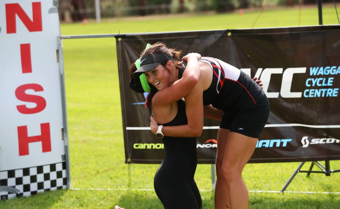 TIGHT TUSSLE: Riverina Tri Series overall winner Chloe Hamblin (left) hugs Claudia Taylor after The Rock Triathlon. Picture: Emma Hillier