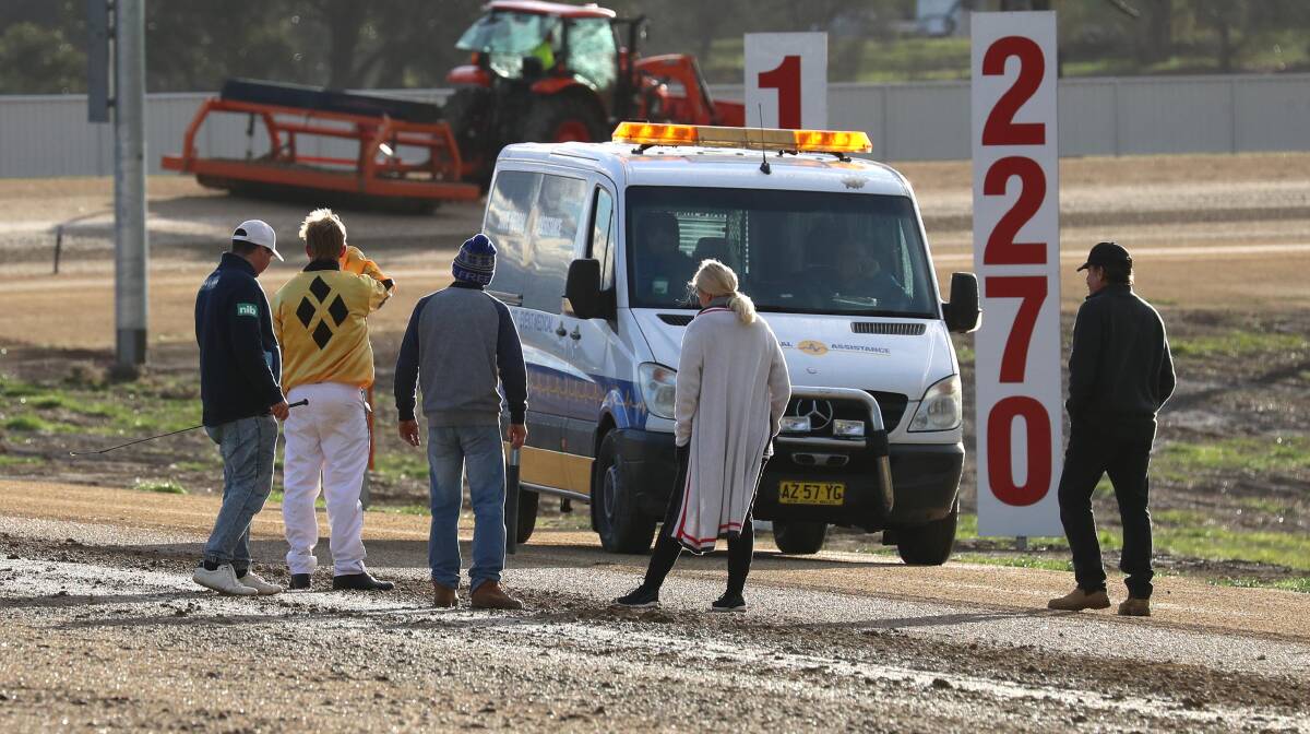 TOO WET: Participants inspect the Riverina Paceway surface after two races were abandoned due to rain in July. Picture: Les Smith