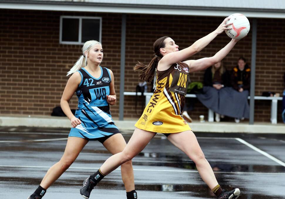 STRETCH FOR IT: Hawk Corinna Bax grabs a pass ahead of Northern Jets' Shelby Worland on Saturday. Picture: Les Smith