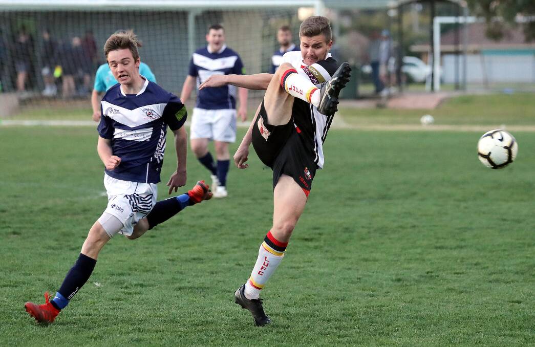 THRILLING VICTORY: Leeton's Daniel McKenzie (right) clears the ball ahead of Young's Isaac Anderson during Sunday's elimination final. Picture: Les Smith