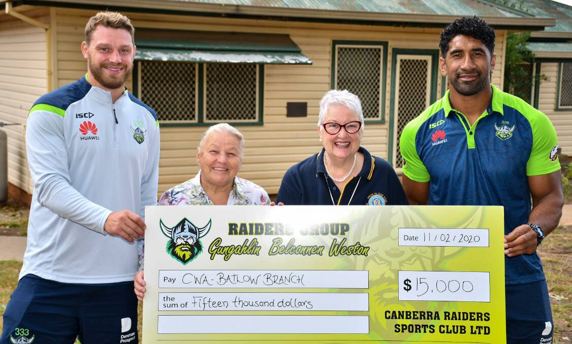 HELPING HAND: Canberra Raiders stars Elliott Whitehead and Sia Soliola present a $15,000 donation to the CWA Batlow branch, which will go toward helping fire affected residents. Picture: Canberra Raiders