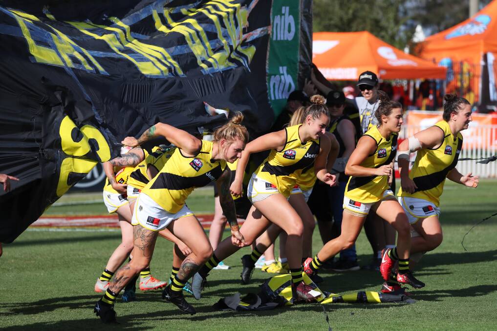 MOMENTUM HALTED: Richmond's AFLW teams runs through the banner before their clash with GSW Giants in Wagga earlier this year Picture: Emma Hillier