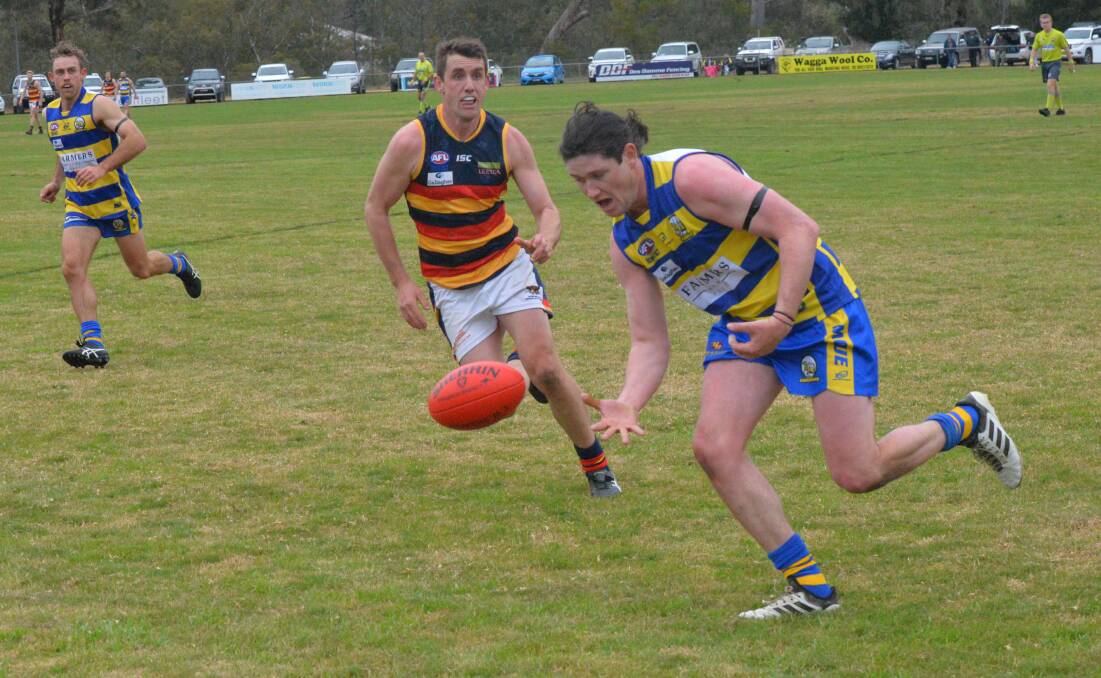 TIGHT TUSSLE: MCUE's Matt Collins tracks down the ball with Leeton-Whitton's Tom Meline in pursuit on Saturday. 