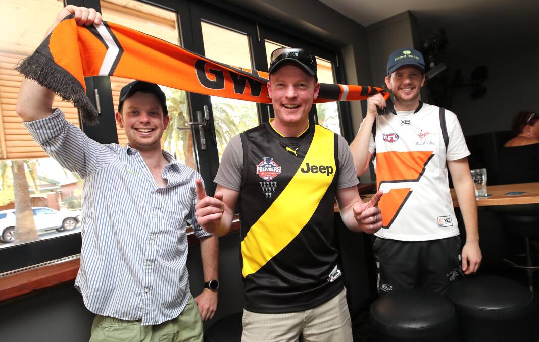 AFL fans Jacob Heard, Symon Parsons and James Lyell don their colours in Wagga for this year's grand final. 