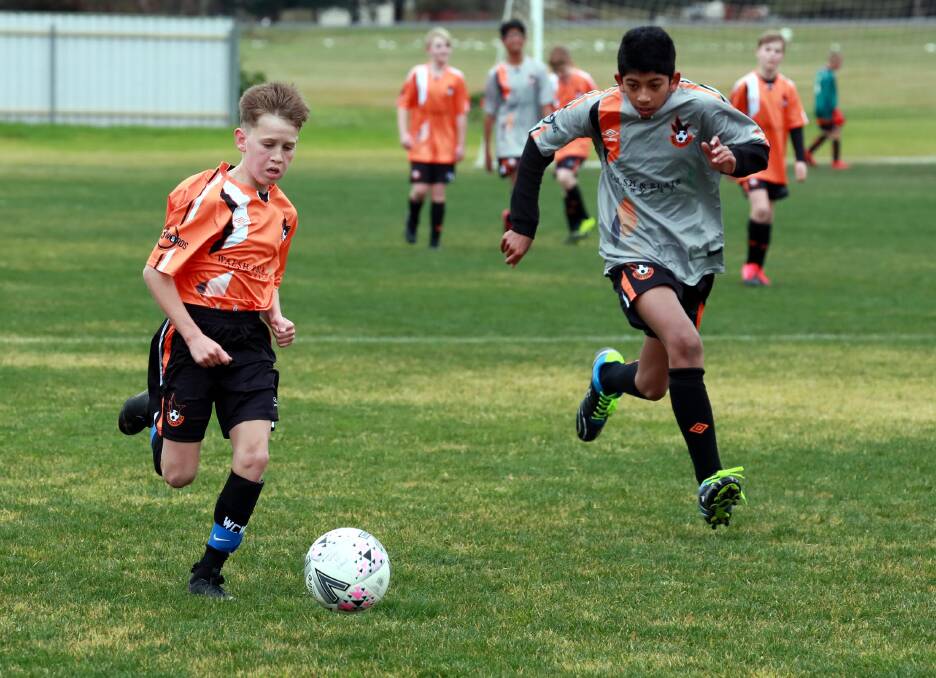 CLUB RIVALRY: Wagga United Crows' Cruz Livermore and Wagga United Swifts' Edwin Tomy chase down the ball. 