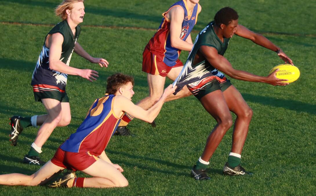 TOO STRONG: TRAC's Gerard Okerenyang tries to power through a Will Adams tackle. Picture: Les Smith