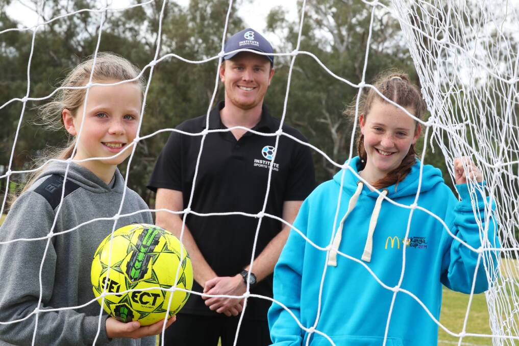 COACHING CLINIC: Western Sydney Wanderers academy coach Christian Layland with local juniors Talia Franklin, nine, and Ella Barrell, 13, at Rawlings Park on Monday. Picture: Emma Hillier 