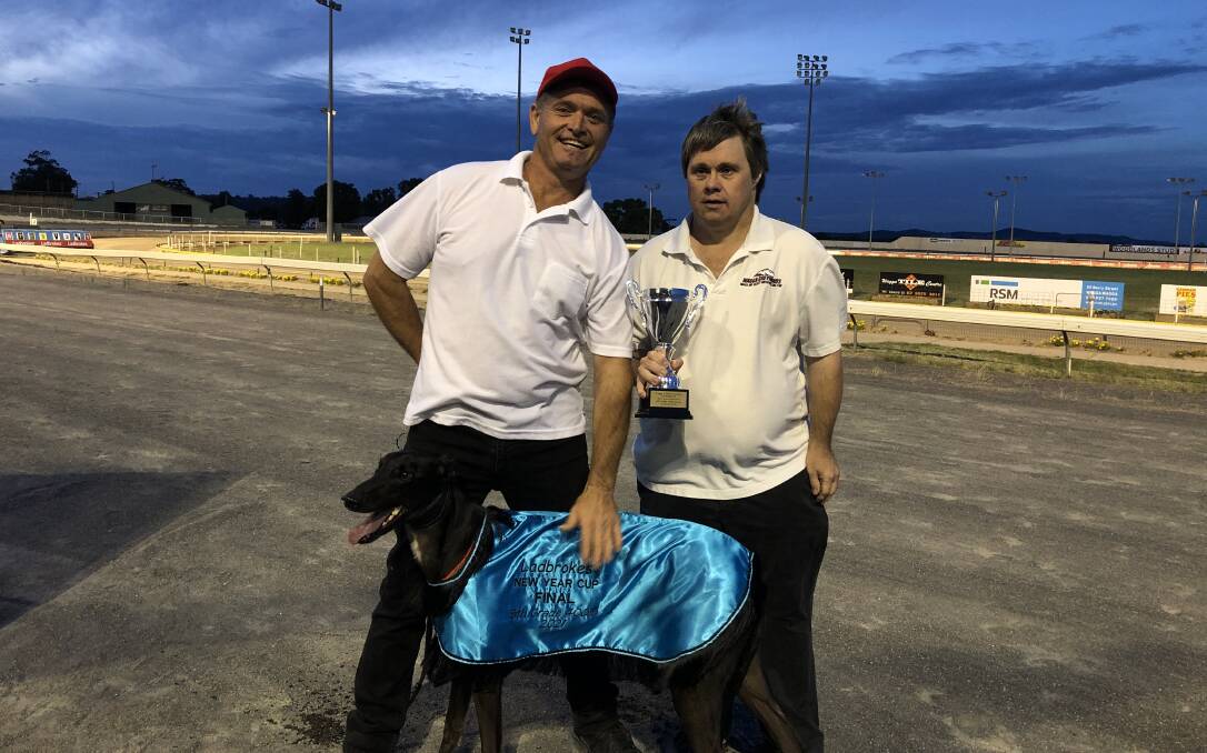 Wagga trainer David Jones is presented the New Year's Cup by Wagga and Greyhound Club's Danny Smith. Picture: Peter Doherty