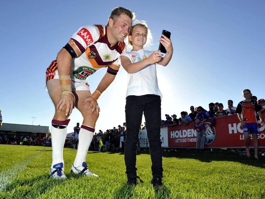 HOMECOMING: Ryan Hinchcliffe, pictured posing with Junee youngster Macey Crane before the 2015 City-Country game in Wagga, will return for a coaching clinic next weekend. Picture: Les Smith