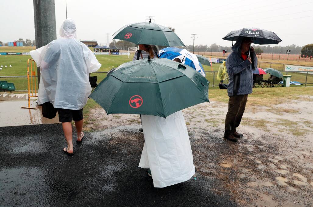 TOUGH CONDITIONS: Fans seek cover from the rain during Sunday's W-League trial at Equex Centre. Picture: Les Smith 