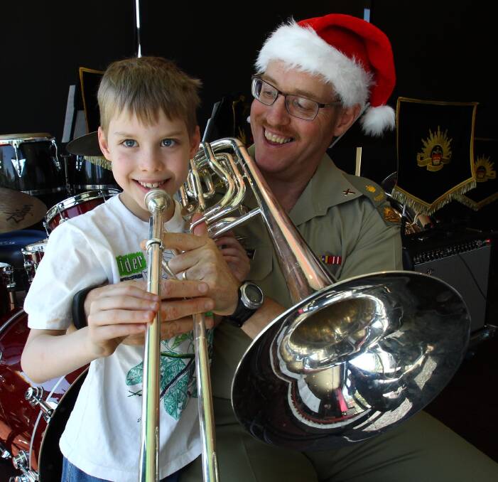 CHRISTMAS SPIRIT: Kapooka army chaplain and musician Andrew Osborne with his seven-year-old son, Edward, help launch the Christmas Spectacular, which will be held on December 13. Picture: Les Smith