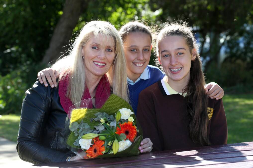 TIME TO SMILE: Tahlia, 14, and Jade, 12, are happy to be able to cuddle their mum, Janine Fabris, after her fight with cancer. Picture: Anthony Stipo 