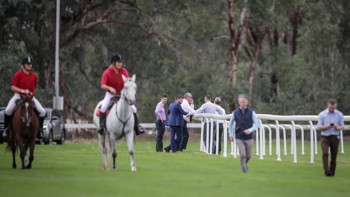 WASHED OUT: Stewards and club officials look over the problem section of the Albury track on Friday. Picture: James Wiltshire