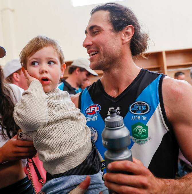 Mitch Haddrill with two-year-old son Lance in the Northern Jets' rooms after the preliminary final win last Saturday. Picture by Les Smith