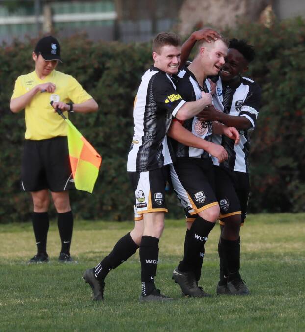 WELCOME BACK: Carl Pideski is flanked by his Wanderers teammates after scoring a goal in the second half against ANU at Gissing Oval on Saturday. Picture: Les Smith