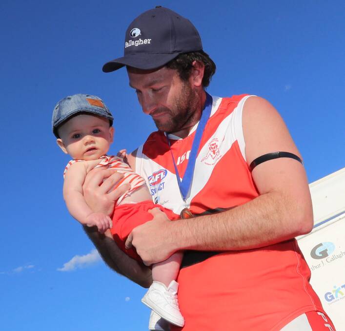 Marc Geppert with son Hutch after the 2018 premiership.
