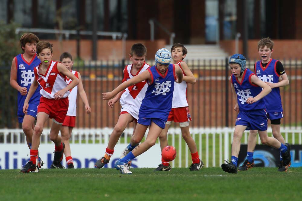 TIGHT BATTLE: Players from Wagga and District and South West hunt the ball in the under 12 representative game at Robertson Oval on Saturday. Picture: AFL Riverina