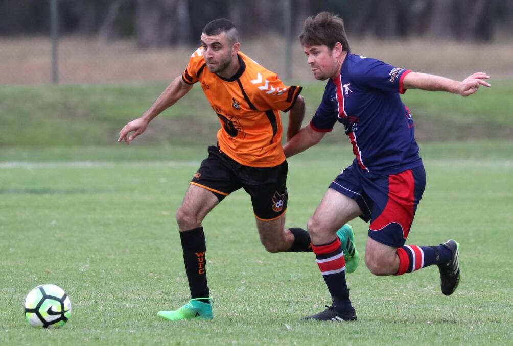 TIGHT TUSSLE: Wagga United's Nazar Yousif and Henwood Park's Matt Menser tussle for the ball at Rawlings Park on Sunday. Picture: Les Smith