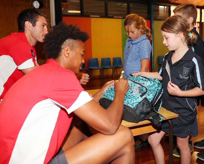 Joel Amartey signs an autograph for Ella Fairman at Wagga Public School on Tuesday. Picture: Kieren L Tilly