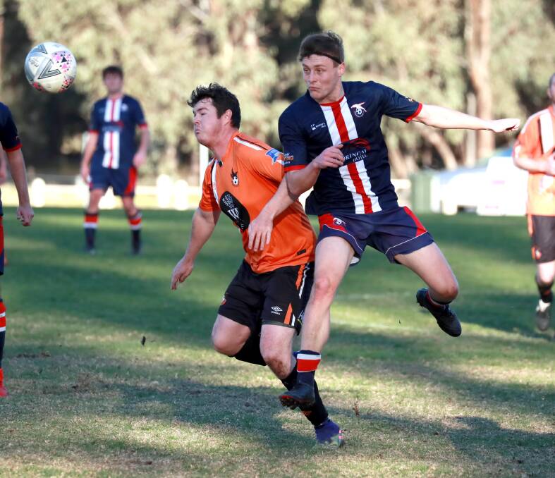 STRONG CHALLENGE: Wagga United's Patrick Chambers and Henwood Park's Matthew Cain compete at Rawlings Park on Sunday. Picture: Les Smith